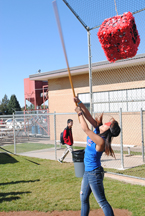 A student tries to connect with one of the pinatas.
